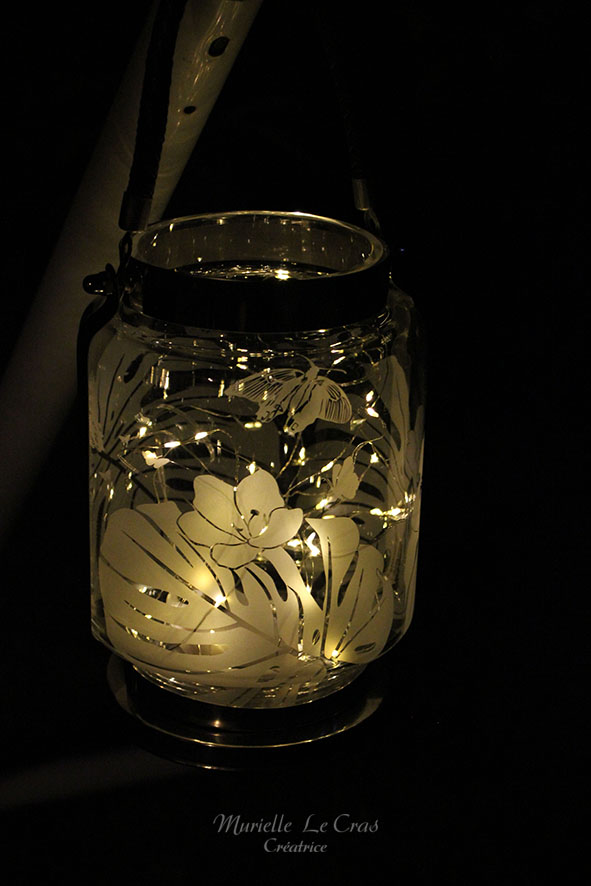 Photophore style lampe tempête de marin avec des fleurs, des feuilles de philodendron et des papillons