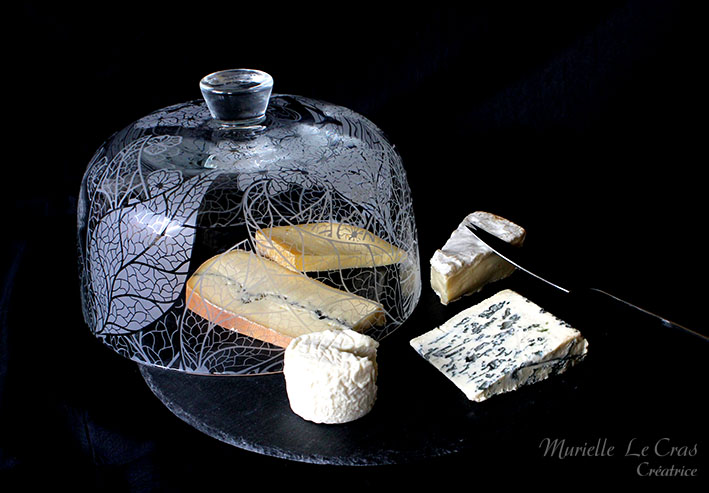 Plateau à fromage en ardoise avec une coupe cloche en verre personnalisée avec un motif de feuilles et fleurs travaillé graphiquement sur le principe des rainures