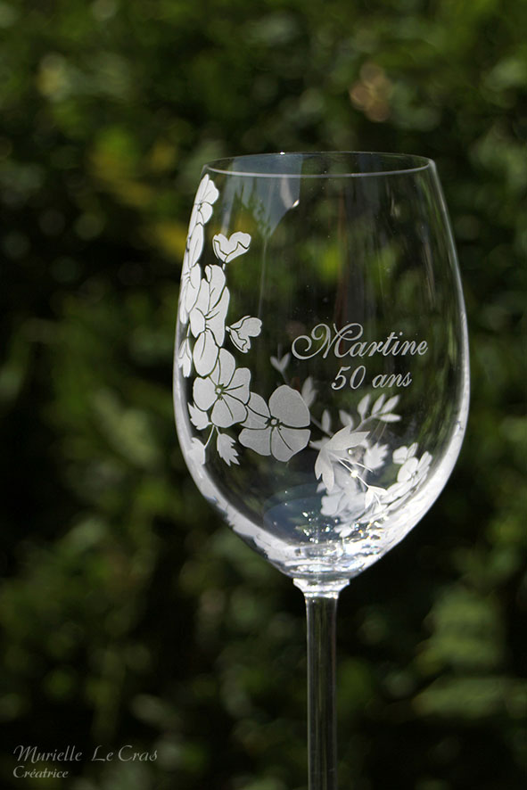 Verre à vin personnalisé avec un motif floral gravé qui enveloppe le verre sur une partie avec un prénom. cadeau pour un anniversaire