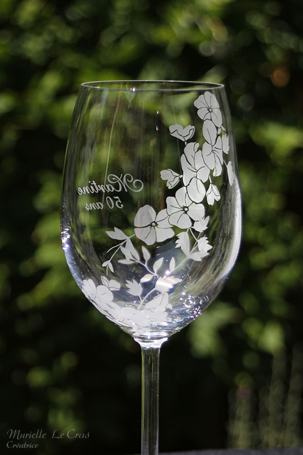 Verre à vin personnalisé avec un motif floral gravé qui enveloppe le verre sur une partie avec un prénom. cadeau pour un anniversaire