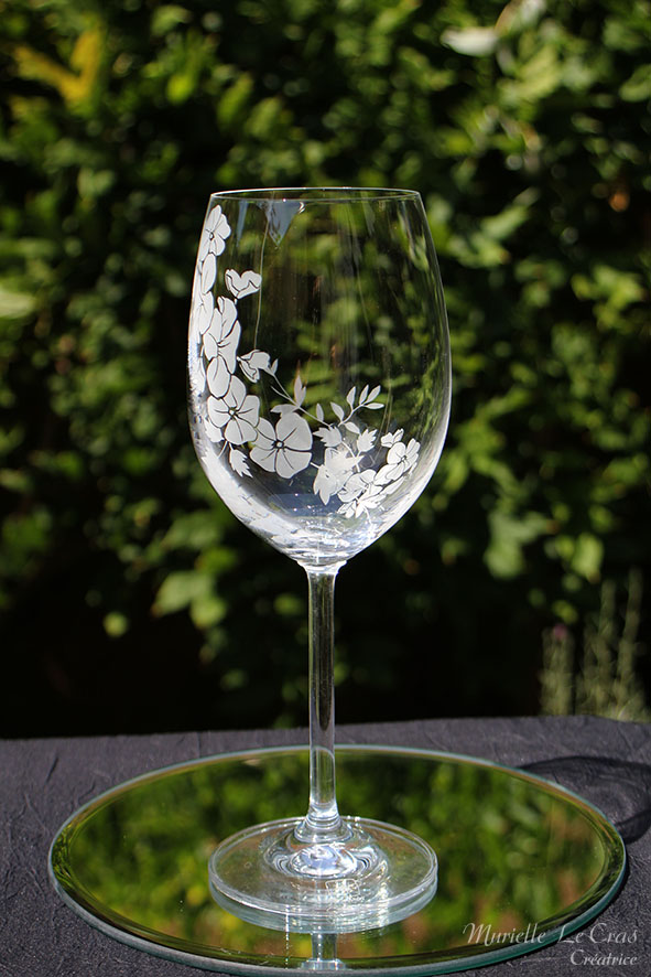 Verre à vin personnalisé avec un motif floral gravé qui enveloppe le verre sur une partie avec un prénom. cadeau pour un anniversaire