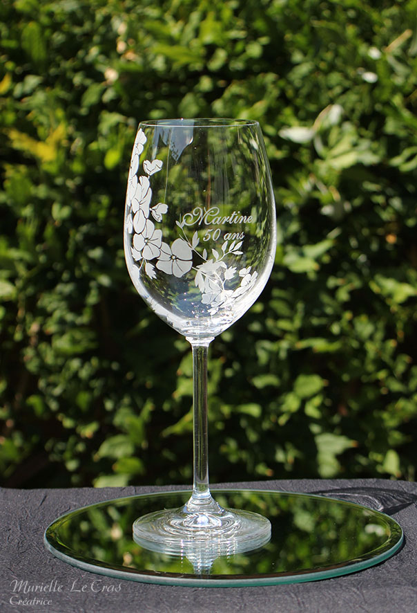 Verre à vin personnalisé avec un motif floral gravé qui enveloppe le verre sur une partie avec un prénom. cadeau pour un anniversaire