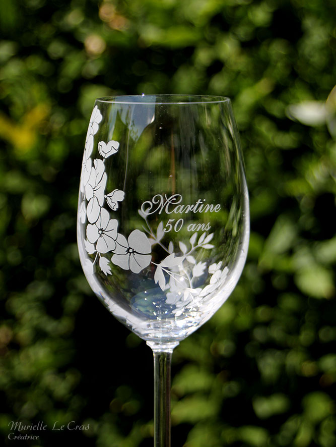 Verre à vin personnalisé avec un motif floral gravé qui enveloppe le verre sur une partie avec un prénom. cadeau pour un anniversaire