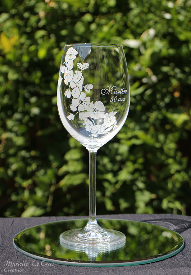 Verre à vin personnalisé avec un motif floral gravé qui enveloppe le verre sur une partie avec un prénom. cadeau pour un anniversaire