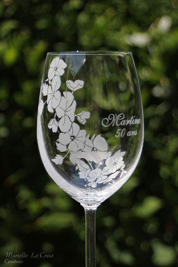 Verre à vin personnalisé avec un motif floral gravé qui enveloppe le verre sur une partie avec un prénom. cadeau pour un anniversaire