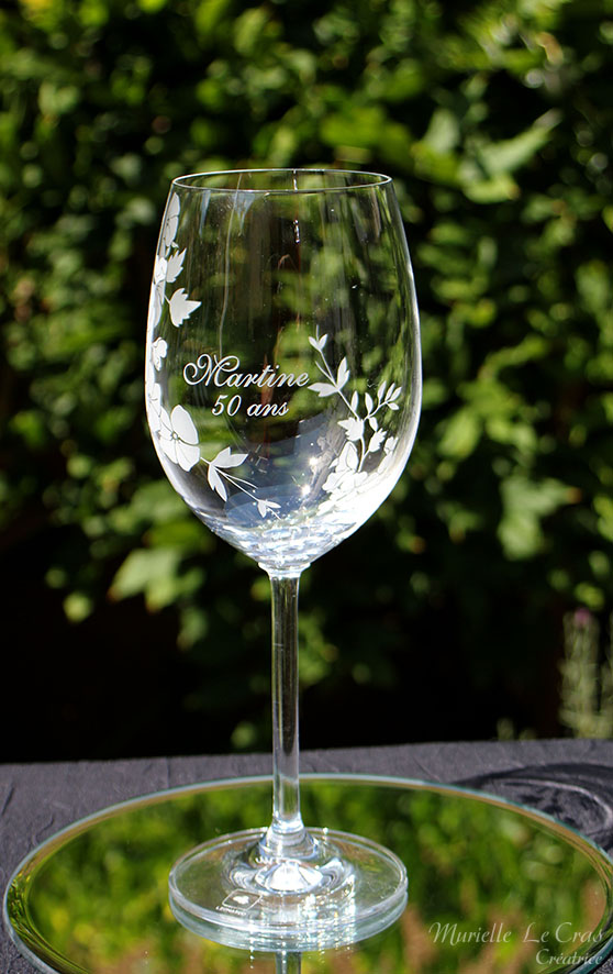 Verre à vin personnalisé avec un motif floral gravé qui enveloppe le verre sur une partie avec un prénom. cadeau pour un anniversaire