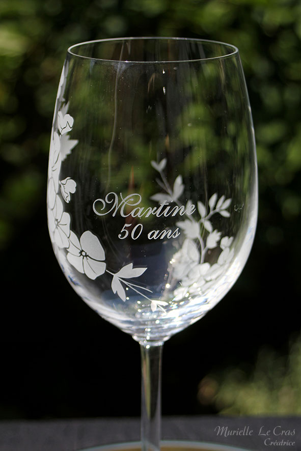 Verre à vin personnalisé avec un motif floral gravé qui enveloppe le verre sur une partie avec un prénom. cadeau pour un anniversaire