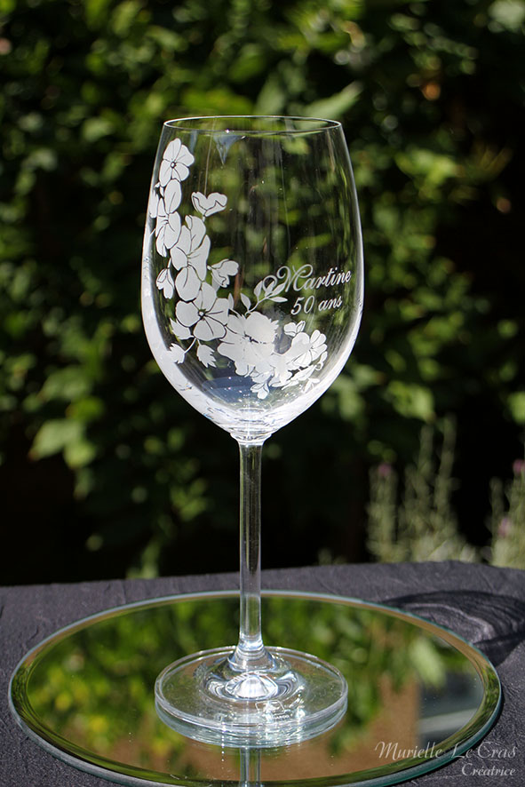 Verre à vin personnalisé avec un motif floral gravé qui enveloppe le verre sur une partie avec un prénom. cadeau pour un anniversaire