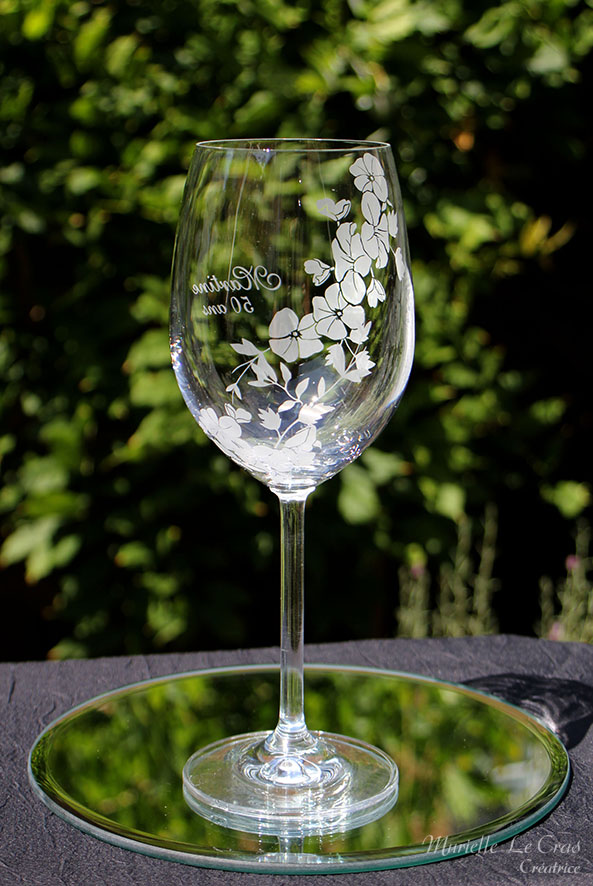 Verre à vin personnalisé avec un motif floral gravé qui enveloppe le verre sur une partie avec un prénom. cadeau pour un anniversaire