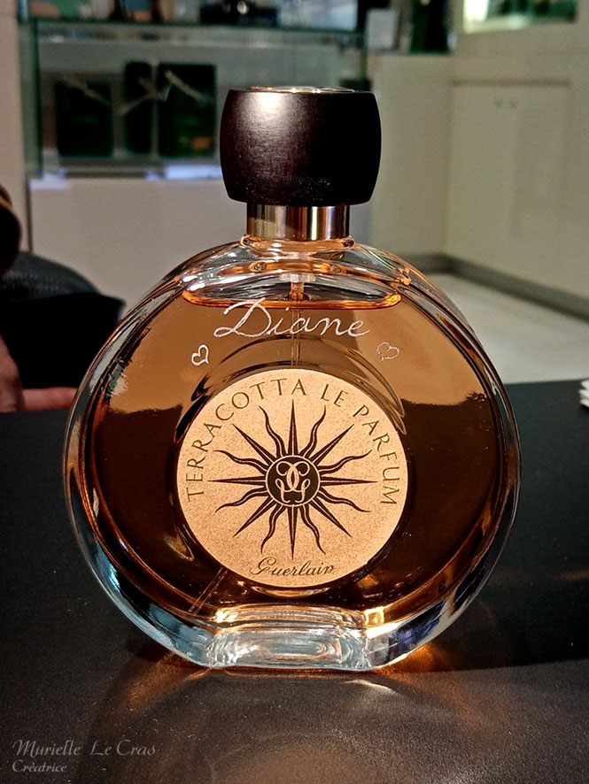 Flacon de parfum Guerlain, personnalisé avec un prénom gravé et des cœurs.